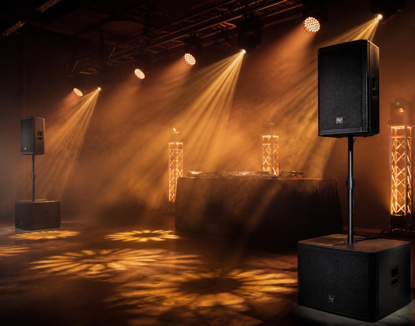 Soundanlage und Lichttechnik mit warmen Lichtkegeln in einer Eventhalle